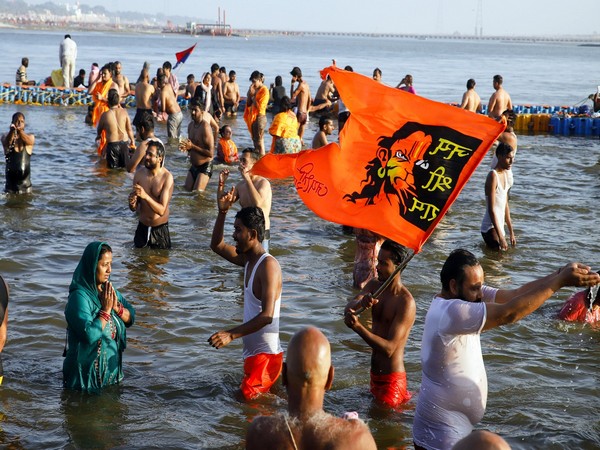 A devotee holding a 'Jai Shree Ram' flag takes a dip at Triveni Sangam during the ongoing 'MahaKumbh' (Photo/ANI)