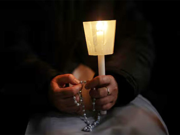 A nun holds a candle and a rosary during a prayer service in St. Peter's Square, as Pope Francis continues his hospitalization, at the Vatican (Image/Reuters)