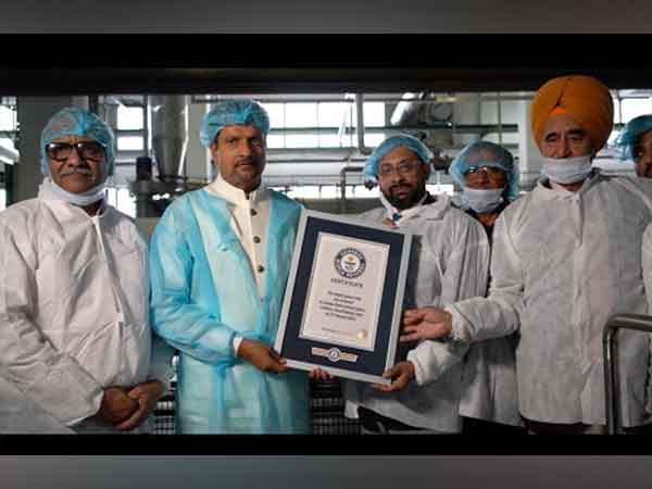 Dr. Radhey Shyam Dixit, Chairman of Ananda Dairy, with his team, proudly holding the Guinness World Record for the Largest Paneer Slab