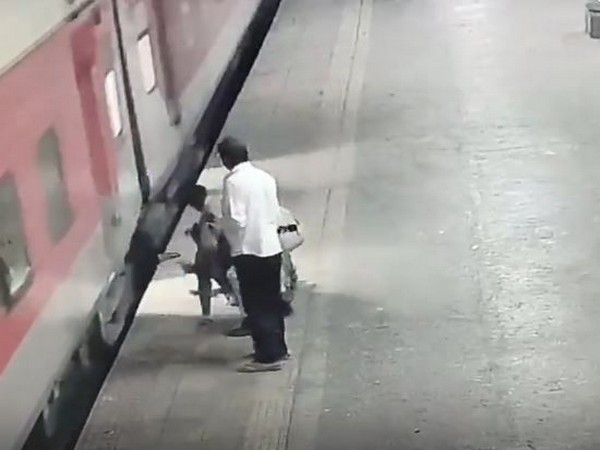 Railway security personnel rescues a woman from being dragged by a moving train at Borivali station (Photo/)