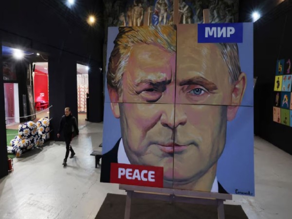 Artist Alexei Sergienko walks towards his painting “Peace to the world