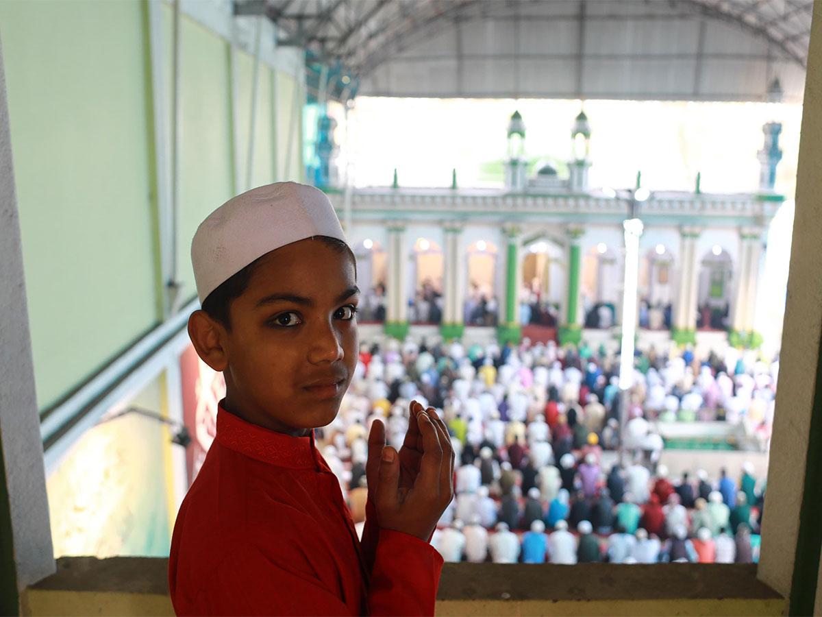 A boy looks on while people pray at a mosque in Nepal (Image/ANI)