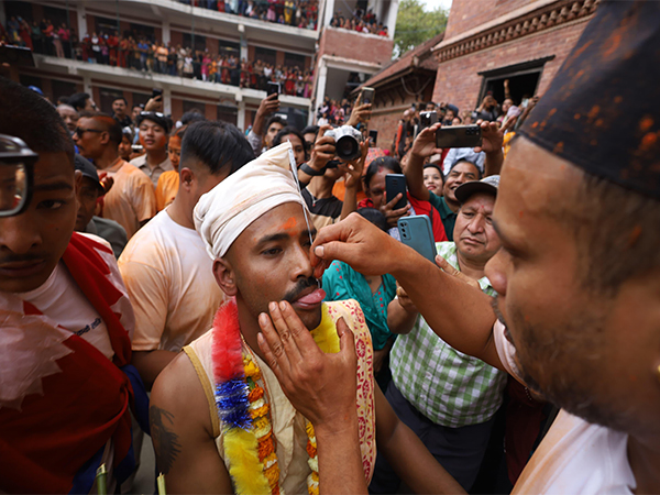 A man pierces his tongue during the 