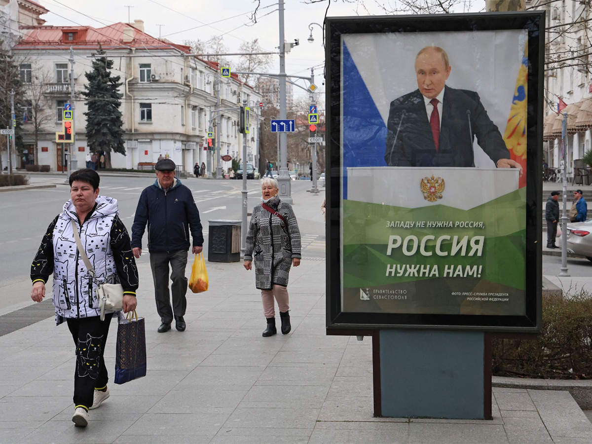 People walk past a banner depicting Russian President Vladimir Putin in Sevastopol, Crimea March 22, 2025 (Photo/Reuters)