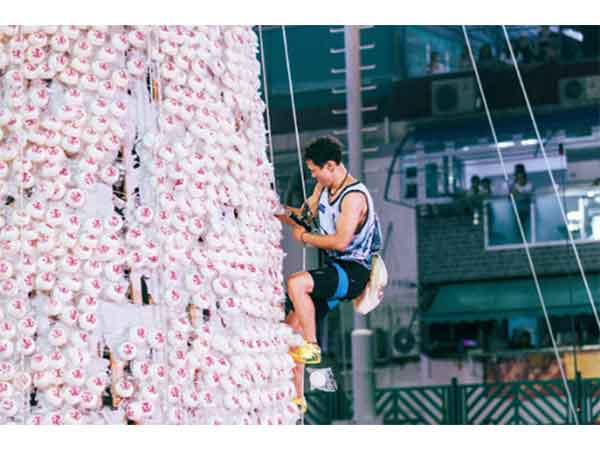 A man participating in the Bun Scrambling Competition during Hong Kong's Cheung Chau Bun Festival