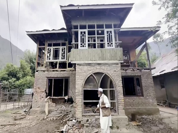 Residents near the damaged house after shelling from Pakistan, in Baramulla (Image/ANI)