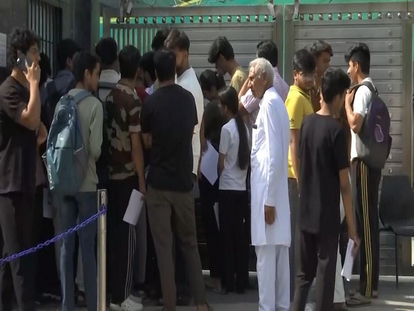 Students and parents wait outside exam centre (Photo/ANI)