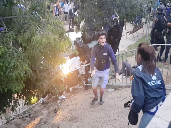 A person held by police personnel in riot gear after a car drove into the crowd near the RCDE Stadium in Barcelona (Image Credit: Reuters)