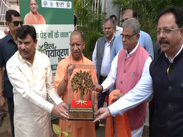 CM Yogi Adityanath plants sapling (Photo/ANI)
