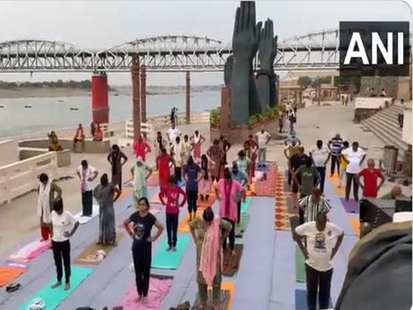 People perform yoga at Namo ghat ahead of the International Yoga Day (Photo/ANI)