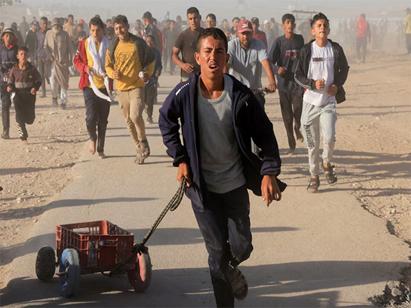 Palestinians walk to collect aid supplies from the U.S.-backed Gaza Humanitarian Foundation, in Khan Younis, in the southern Gaza Strip (Image/Reuters)