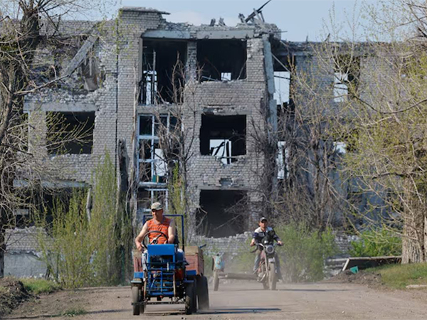 Men ride vehicles near a building destroyed in the course of Russia-Ukraine conflict in Toshkivka (Toshkovka) in the Luhansk region, a Russian-controlled area of Ukraine (Image/Reuters)