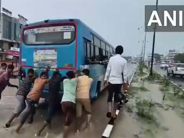 Vehicles struggle to cross a severely waterlogged road in Tharad (Photo/ANI)