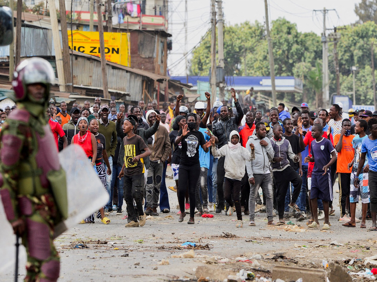 A riot police officer stands near protestors (Photo/Reuters)