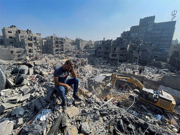 A man sits amid the rubble of destroyed buildings in Gaza following Israeli airstrikes (Source: Reuters)