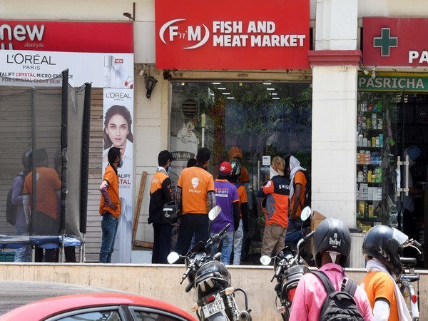 Delivery boys waiting outside store to pick their orders (Photo/ANI)  