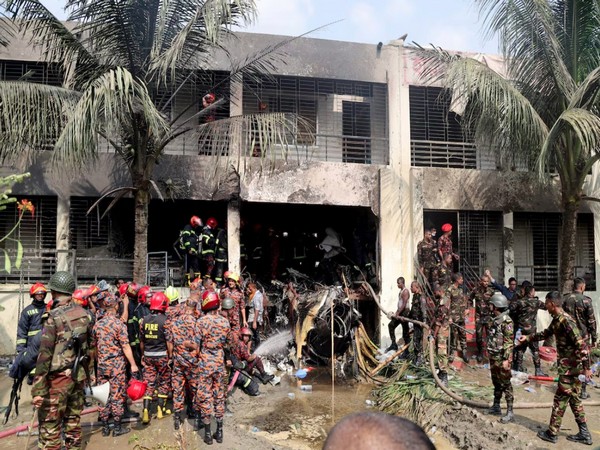 Firefighters and soldiers work next to the wreckage of an air force training aircraft after it crashed into Milestone College campus, in Dhaka (Image/Reuters)