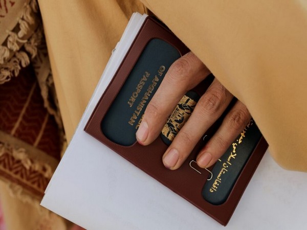 An Afghan citizen holds a passport (Source: Reuters)