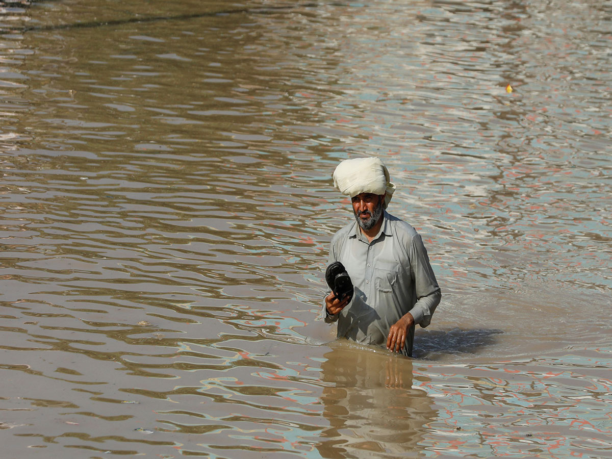 A man wades through floodwaters in Pakistan (Source: Reuters)