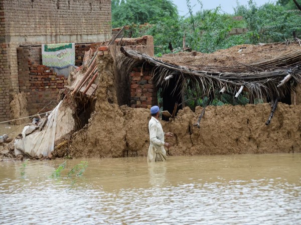 Residents wade through floodwaters in Pakistan (Source: Reuters)