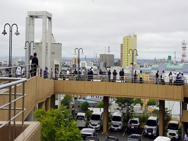 People look on after being evacuated to a temporary tsunami evacuation site in Japan (Image/Reuters)