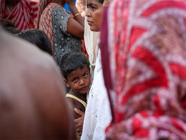A boy stands with his mother inside a makeshift shelter (Image/Reuters)