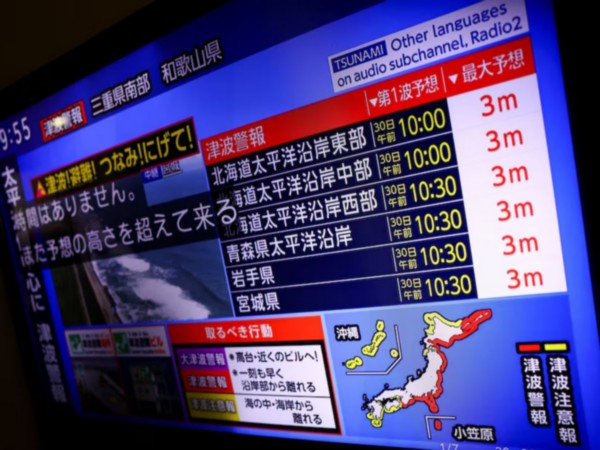 A television screen shows a news report on Japan Weather Agency's tsunami warning, saying it expected tsunami waves of up to 3 meters (Image/Reuters)