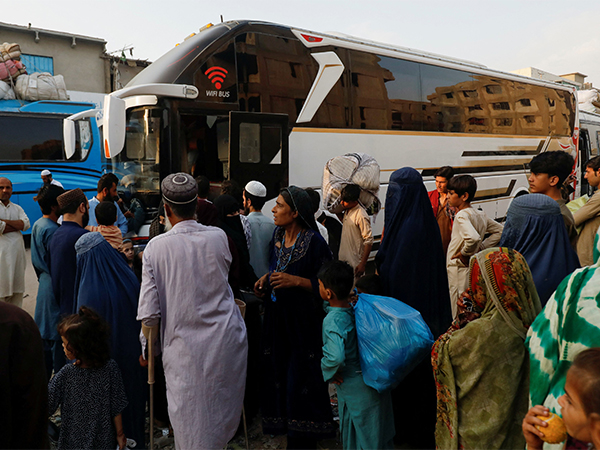 Afghan families board buses with their belongings after being forced to return, highlighting the growing refugee crisis (Photo/Reuters)