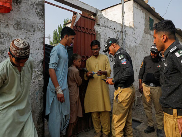 Police and NADRA officials verify Afghan citizens’ IDs during a door-to-door check in a Karachi refugee camp (File Photo/Reuters)