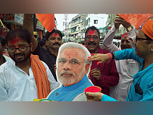 A BJP supporter puts tilak on statue of PM Modi while celebrating scrapping of Article 370 (Photo/ANI)