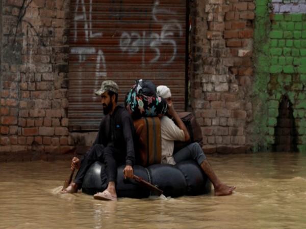 People wade through floodwaters after heavy monsoon rains in Pakistan (Photo/Reuters)