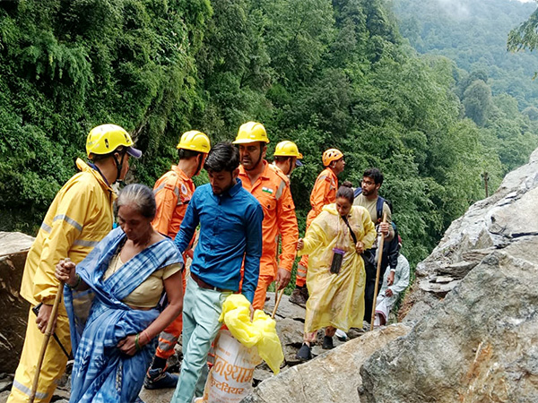 NDRF and SDRF personnel assist people moving through blocked route of Kedarnath Dham (Image/ANI) NDRF and SDRF personnel assist people moving through blocked route of Kedarnath Dham (Image/ANI)