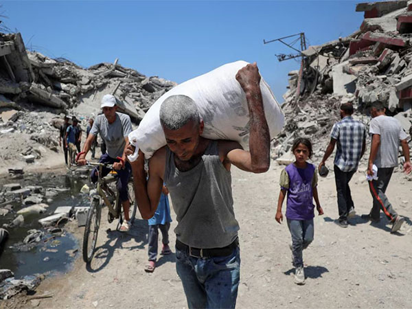 A Palestinian carries a bag with aid supplies that entered Gaza through Israel (Image/Reuters)