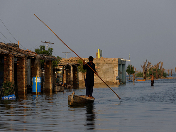 Flood-hit residents wade through waterlogged streets as PMD warns of heavy rains and possible flooding across Pakistan from August 17 (Photo/Reuters)