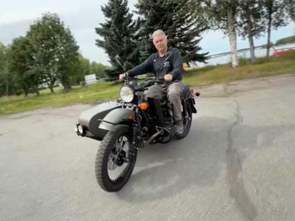 Alaska resident Mark Warren rides a Ural motorcycle gifted by Russian President Vladimir Putin, after receiving it from a Russian Embassy official in Anchorage, US (Photo/Reuters)