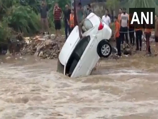 Crane lifts a car swept away by water flow in Kathua (Photo/ANI)