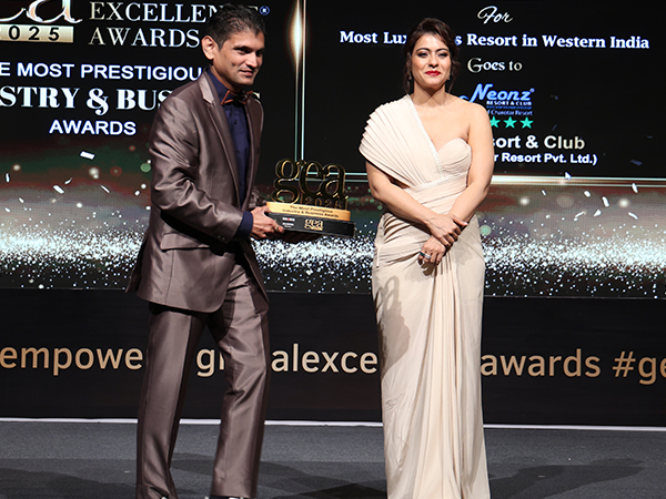 On stage at the Global Excellence Awards 2025, Paritosh Kale, Operations Manager of Neonz Resort & Club, receives the award for Most Luxurious Resort in Western India from Kajol Devgan