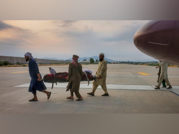 Locals assist Taliban soldiers in carrying victims after the earthquake in Afghanistan (Photo/Reuters)