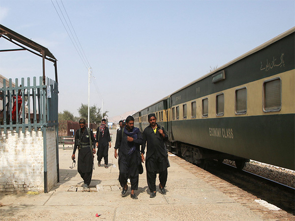 Passengers walk past a halted Pakistan Railways train at a station in Punjab (Photo/Reuters)