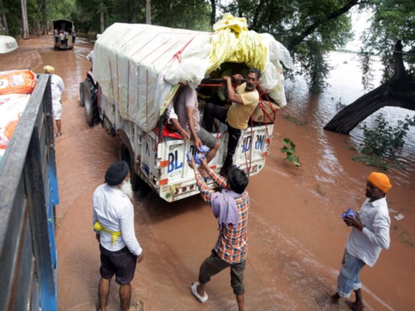 People receive relief material amid flood situation in Punjab (Photo/ANI) People receive relief material amid flood situation in Punjab (Photo/ANI)