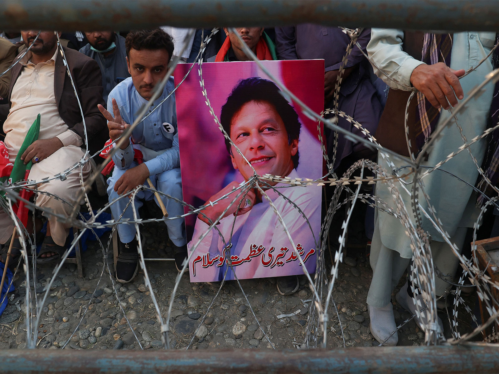 A supporter of jailed former Pakistani Prime Minister Imran Khan's party, the Pakistan Tehreek-e-Insaf holds his poster (Image/Reuters) A supporter of jailed former Pakistani Prime Minister Imran Khan's party, the Pakistan Tehreek-e-Insaf holds his poster (Image/Reuters)