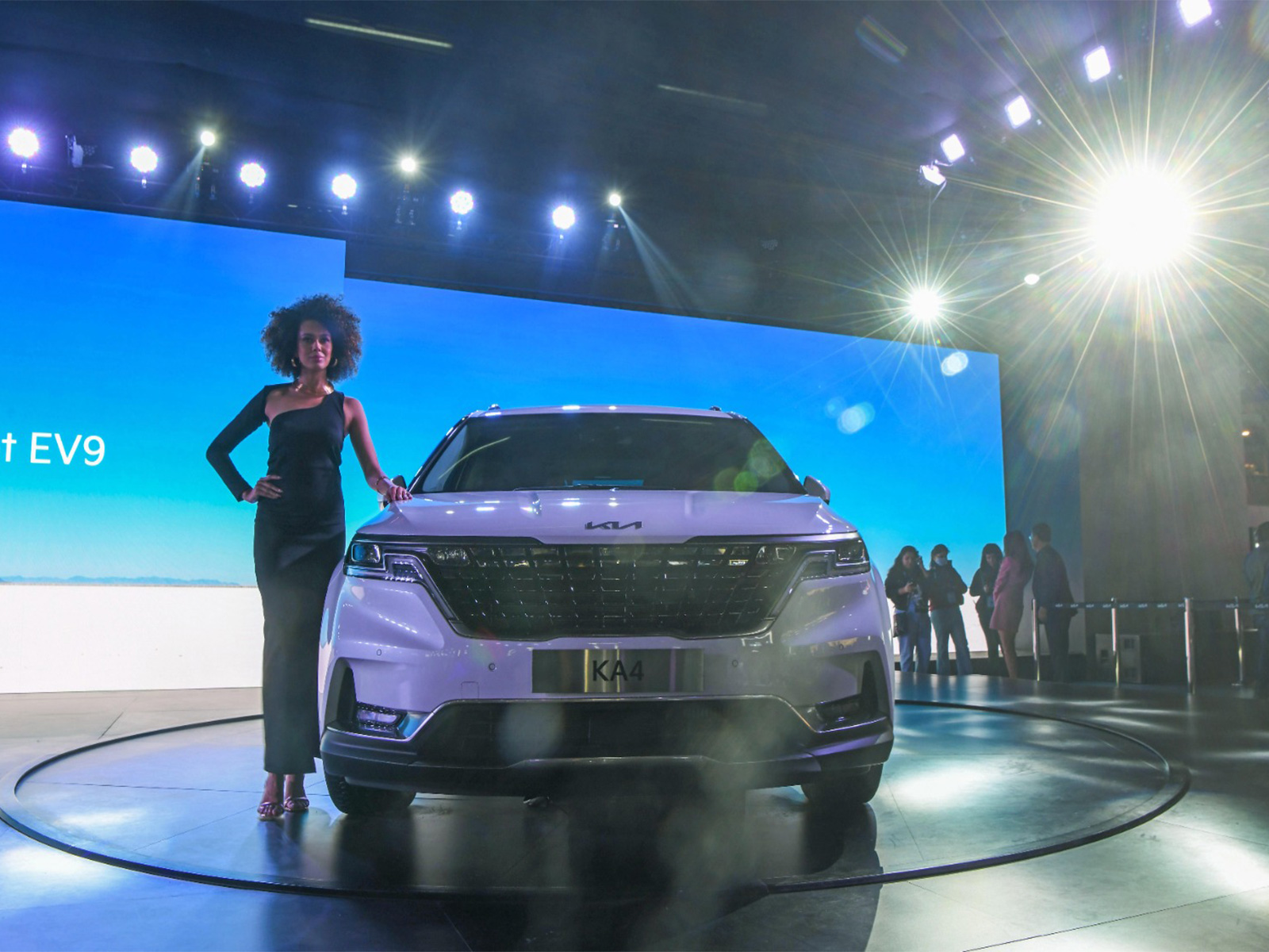 A model poses for a photo with KIA KA4 car at Auto Expo 2023 (Photo/ANI)