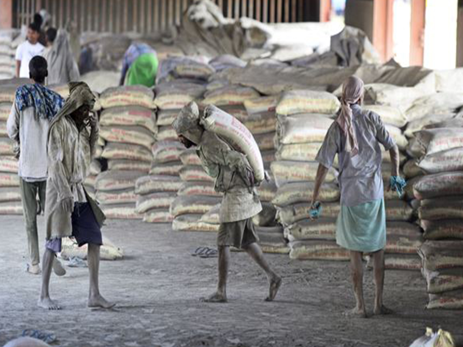 Labourers loading sacks of cement at a warehouse (Photo/ANI)