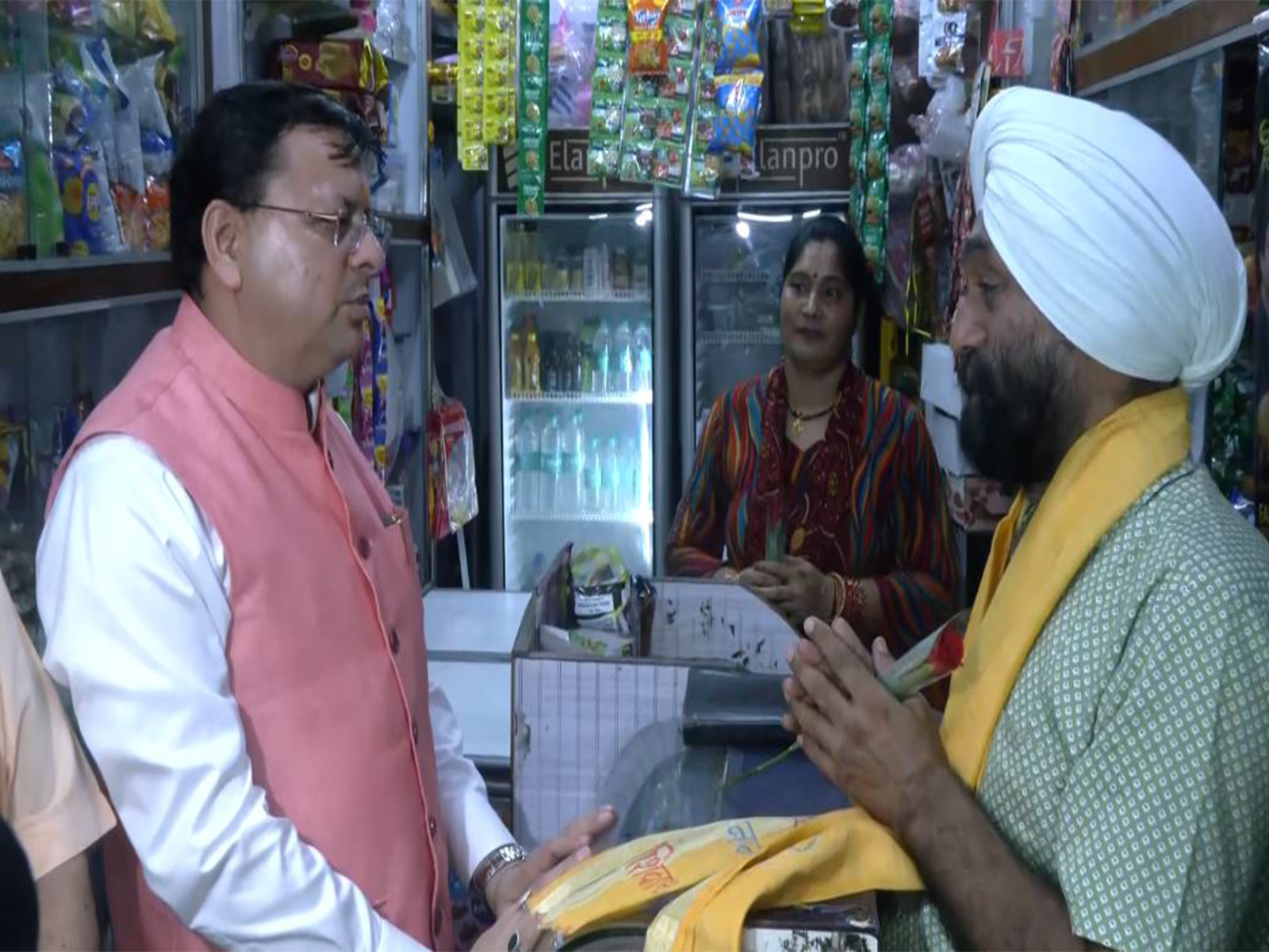 Uttarakhand CM Dhami speaking to a trader. (Photo/ANI)