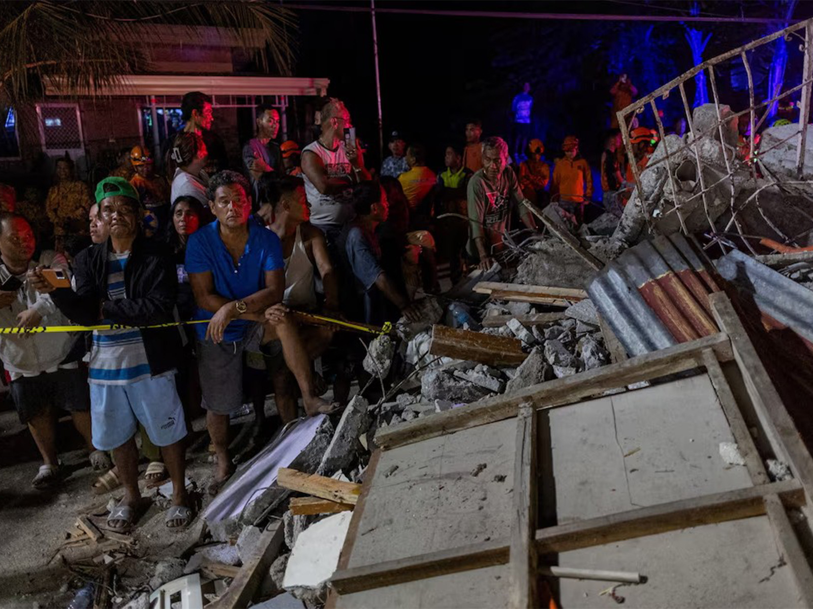 Residents watch as rescuers retrieve bodies of victims in the aftermath of the earthquake in Philippines (Photo/ Reuters)
