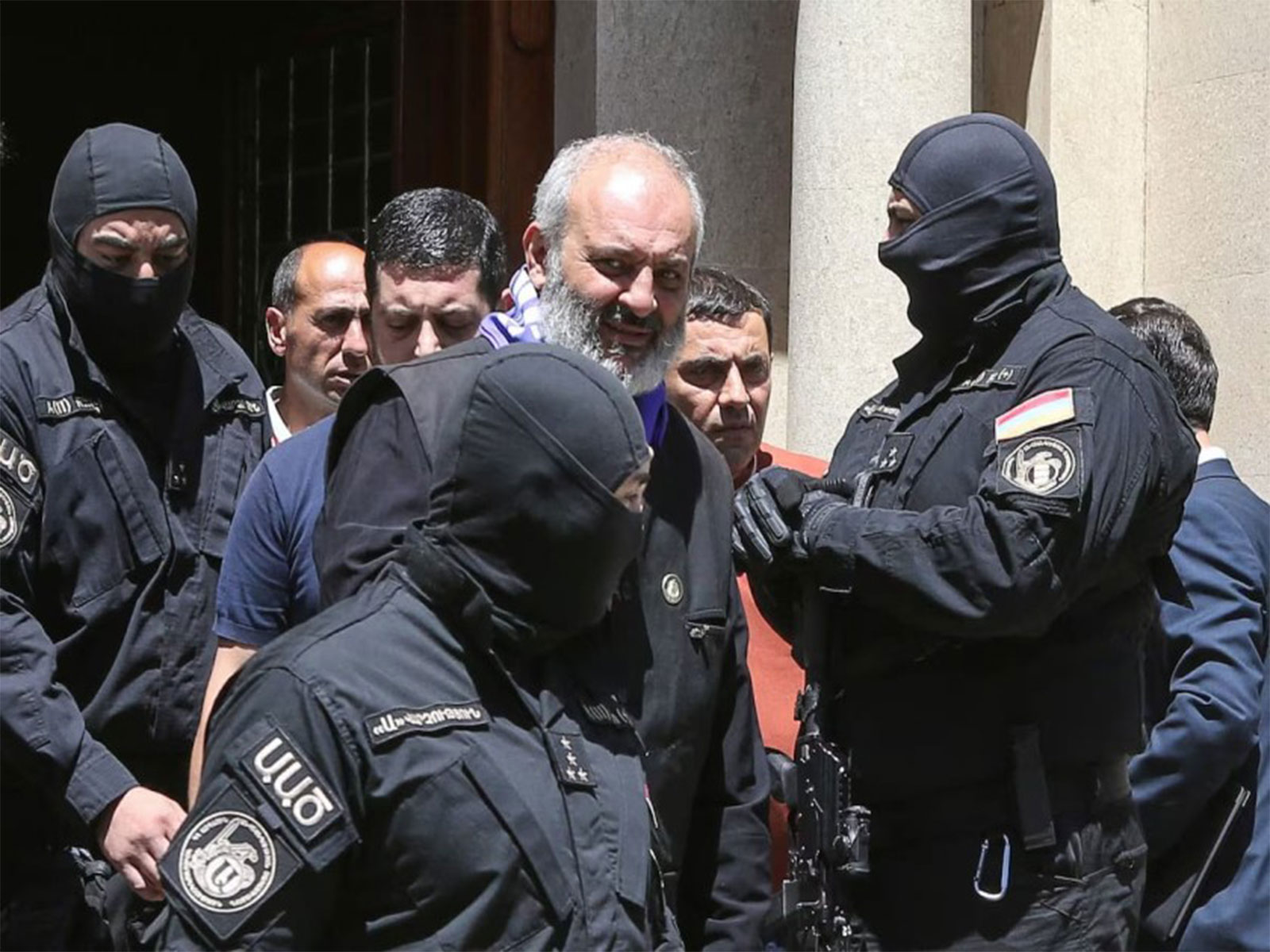 Armed security personnel escort a cleric under detention amid heightened tensions between Armenia’s government and the national church. (File Photo/Reuters)