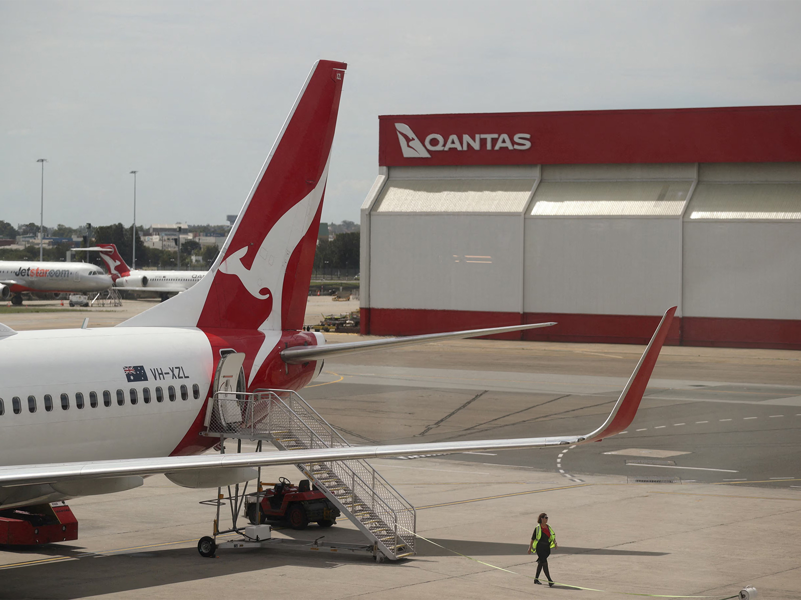 A crew member walks past a Qantas aircraft at the domestic terminal of Sydney Airport in Australia (File Photo/Reuters)