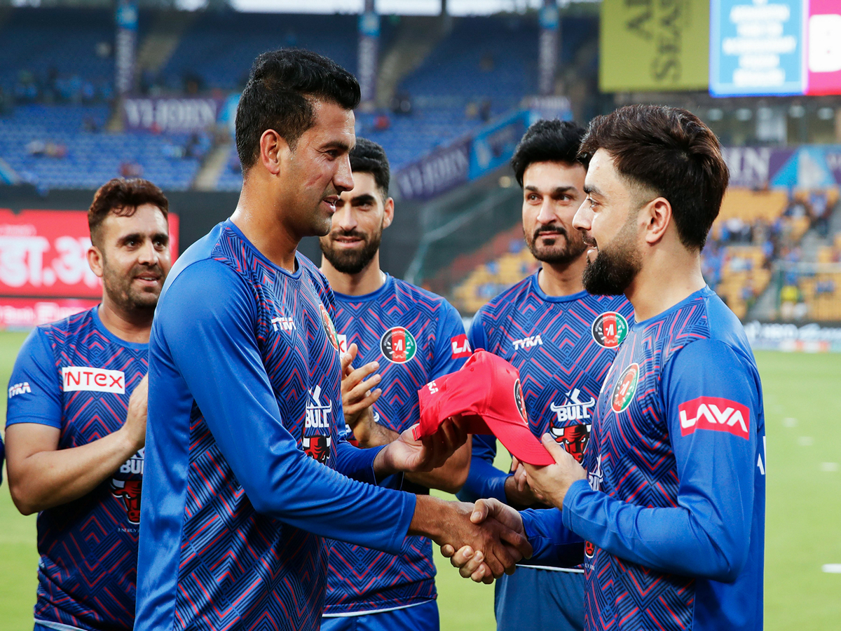 Afghanistan's Mohammad Saleem Safi recieving his debut cap from Rashid Khan. (Photo/ANI)