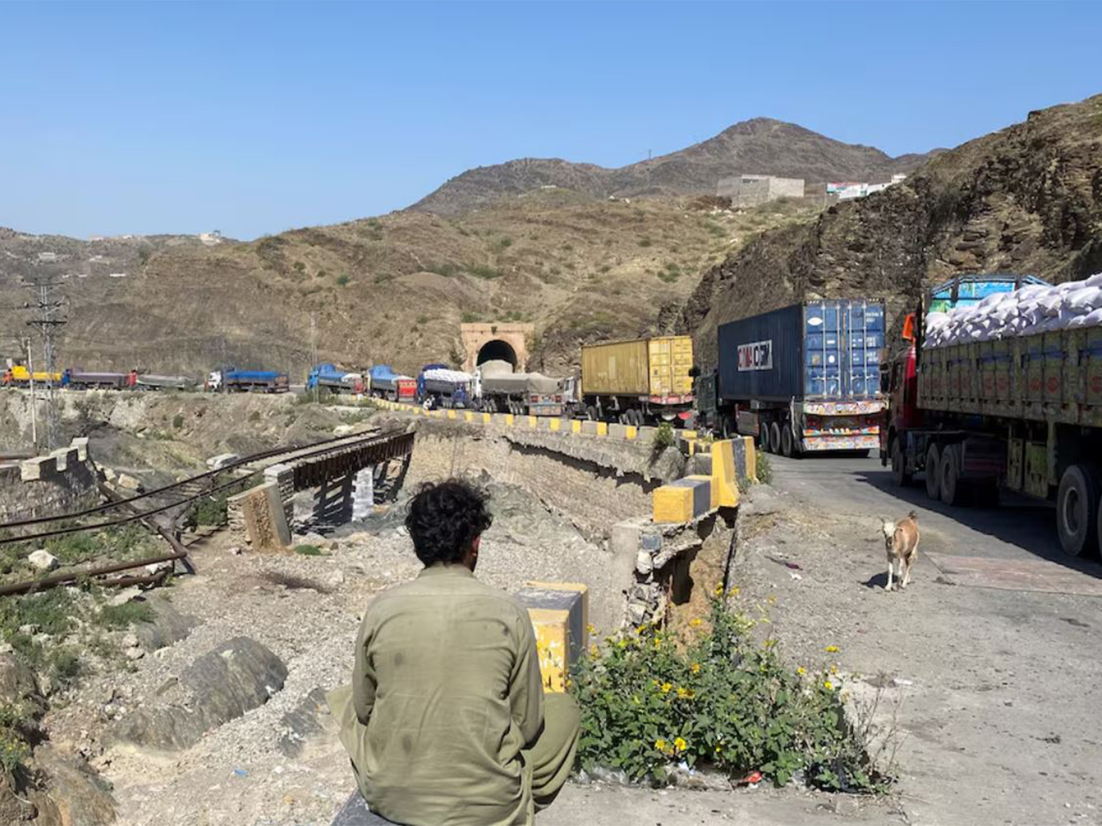 A man sits next to trucks parked at the Torkham border crossing, after Pakistan closed border crossings with Afghanistan, following exchanges of fire between the forces of the two countries, in Torkham, Pakistan (Photo/Reuters)