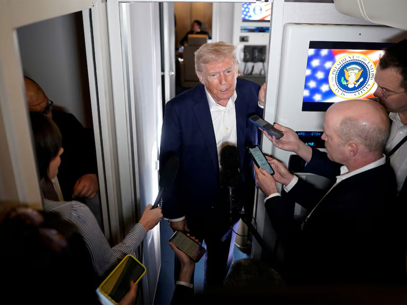 US President Donald Trump speaks to reporters aboard Air Force One during a press gaggle. (Photo/Reuters)
